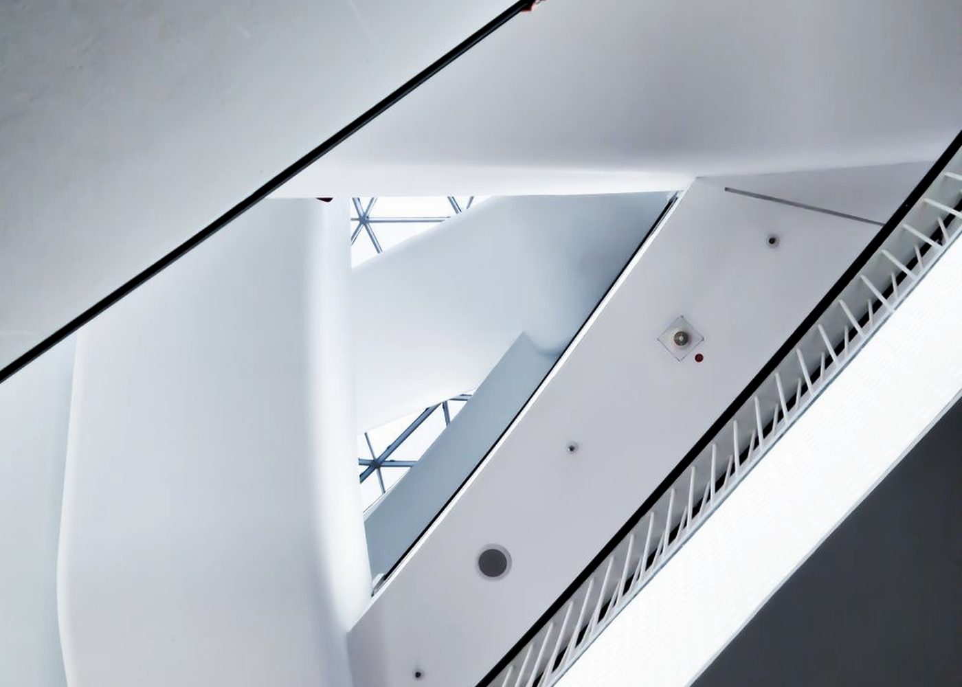 A curved white atrium stair seen from below