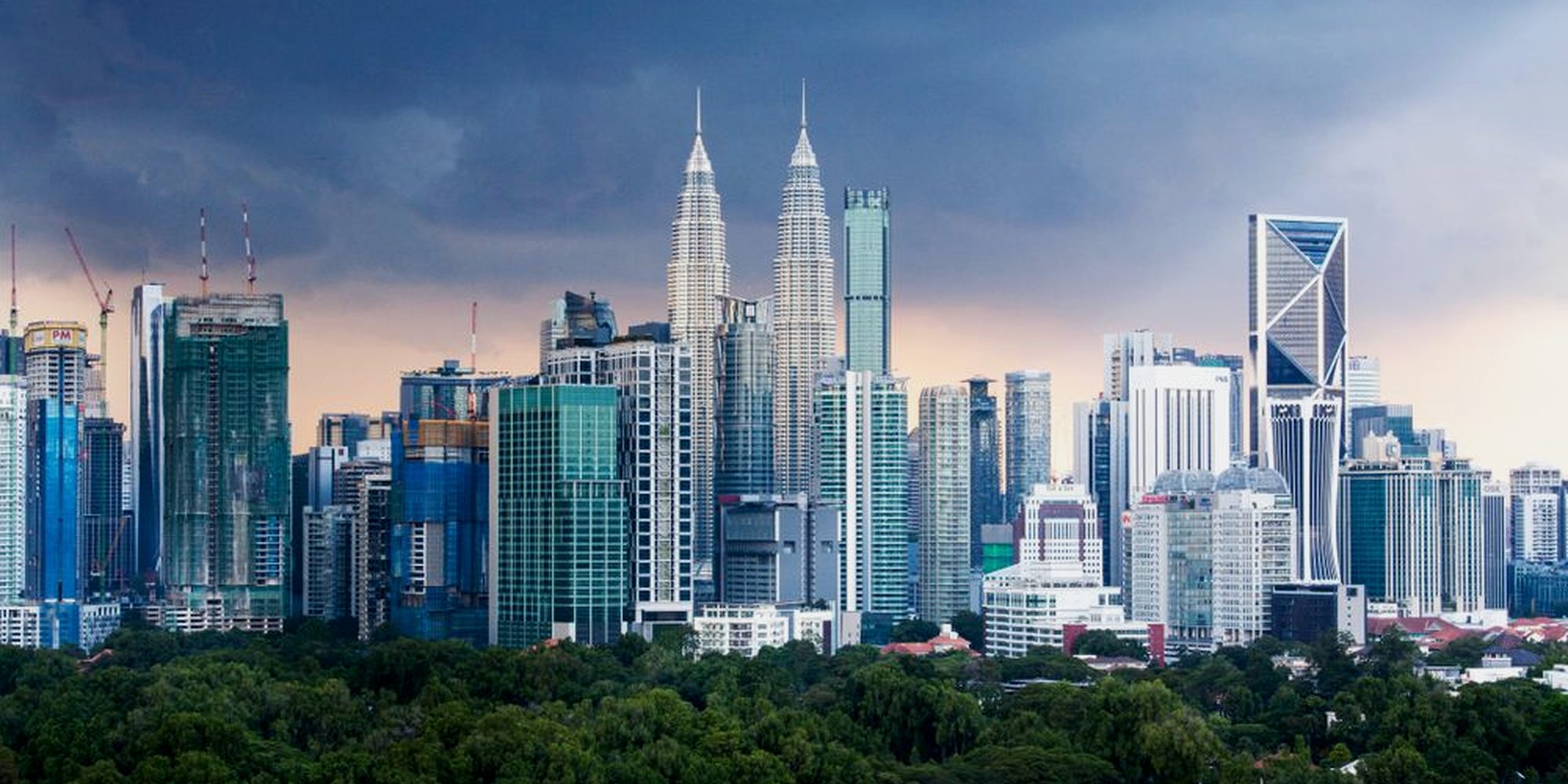 Kuala Lumpur skyline above parkland at dusk