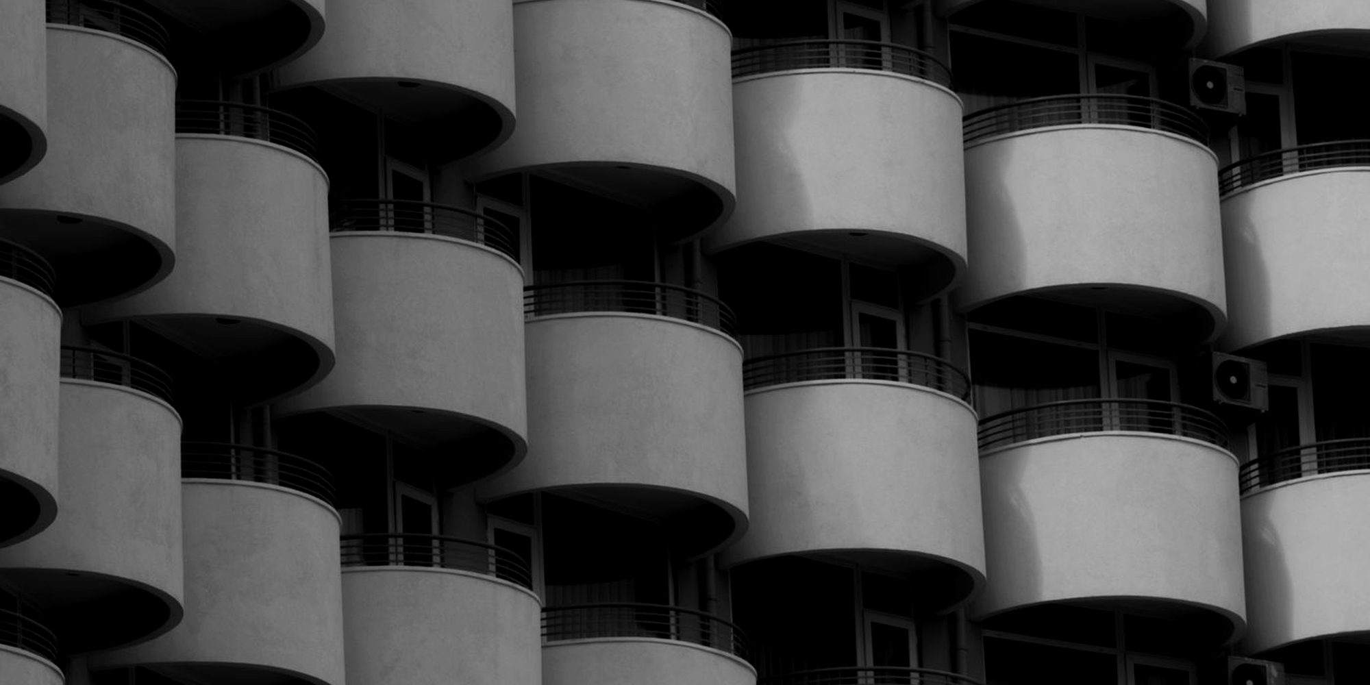 Rounded balconies on a building facade in black and white