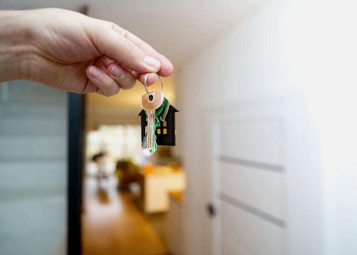 A hand holding a set of keys in a doorway