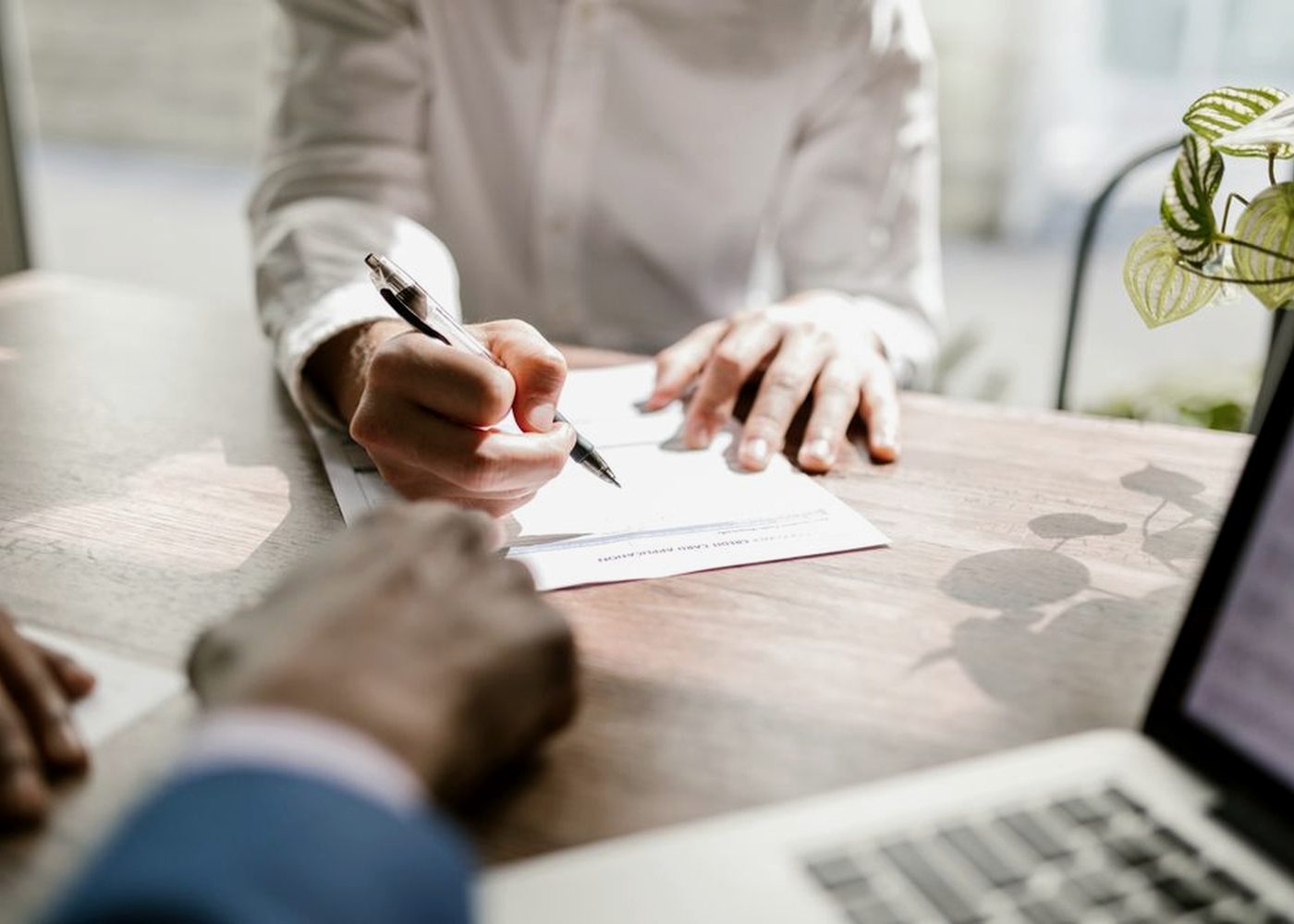 Two people going through a signed agreement at a desk